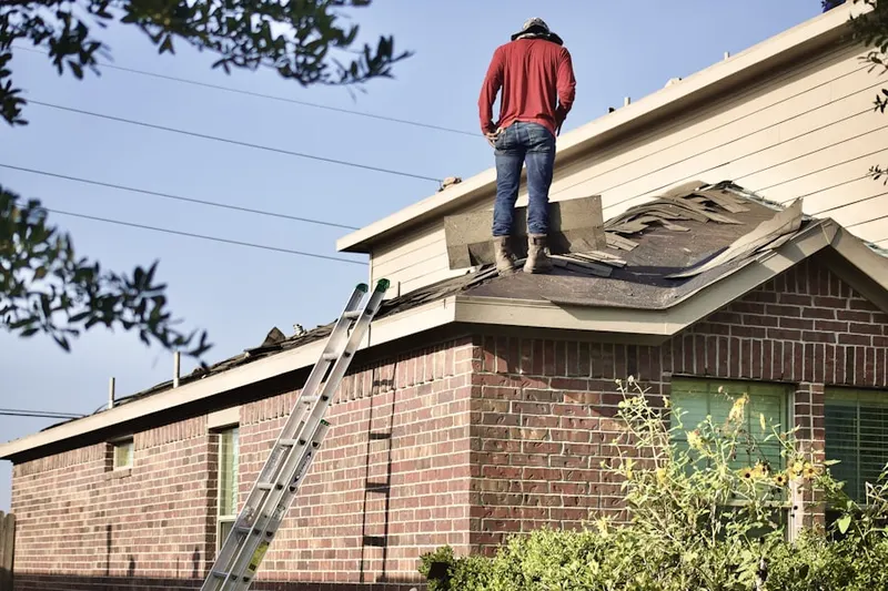 Professional roofer working on a residential roof in Dupreeville